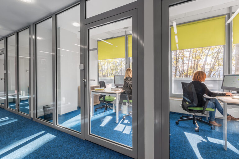 Modern office interior with glass walls, featuring a minimalist design. Relevant to warehouse build-out solutions southeast.